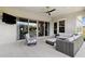 Relaxing covered patio features an outdoor lounge, TV, and sliding glass doors to indoors at 20797 W Rattler Rd, Buckeye, AZ 85396