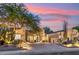 Stunning single-story home with well-lit landscaping and a circular driveway at sunset at 21240 N 74Th Pl, Scottsdale, AZ 85255