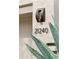 Close-up of a modern house number (21240) next to an agave plant and a modern light fixture at 21240 N 74Th Pl, Scottsdale, AZ 85255