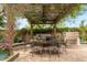 Outdoor dining area with a pergola, built in grill, and lush greenery at 21240 N 74Th Pl, Scottsdale, AZ 85255