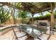 Outdoor dining area with a pergola, built in grill, and lush greenery at 21240 N 74Th Pl, Scottsdale, AZ 85255