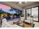 Covered patio with comfortable seating, offering views of the pool and landscaped yard through large glass doors at 21240 N 74Th Pl, Scottsdale, AZ 85255