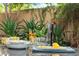 Outdoor dining arrangement with lemon-themed dishware on a granite table, surrounded by lush green plants at 21240 N 74Th Pl, Scottsdale, AZ 85255