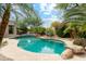 Private pool with rock features and lush landscaping creates a serene outdoor retreat at 21240 N 74Th Pl, Scottsdale, AZ 85255