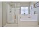Modern bathroom with a glass-enclosed shower and a soaking tub at 21968 W Hadley St, Buckeye, AZ 85326