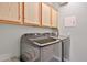 Convenient laundry area with modern appliances, overhead cabinets, and a clean, organized design at 21968 W Hadley St, Buckeye, AZ 85326