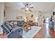 Cozy living room with hardwood floors, a ceiling fan, and plush seating arrangements for relaxing or entertaining at 21968 W Hadley St, Buckeye, AZ 85326