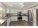 Well-lit kitchen showcasing stainless steel appliances, white cabinets, and hardwood floors at 2438 W Via Dona Rd, Phoenix, AZ 85085