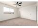 Bright bedroom featuring a ceiling fan, a window and neutral carpeting at 2551 E Harmony Ave, Mesa, AZ 85204