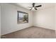 Bedroom featuring a ceiling fan, neutral carpet, and a window with a view at 2551 E Harmony Ave, Mesa, AZ 85204