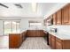 Bright open kitchen area with wood cabinets, marble countertops, and stainless steel appliances at 2551 E Harmony Ave, Mesa, AZ 85204