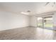 Spacious living room area featuring wood-style flooring, access to the backyard, and ample natural light at 2551 E Harmony Ave, Mesa, AZ 85204