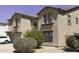 Attractive two-story home with neutral stucco, arched windows, and low-maintenance desert landscaping in the front yard at 25574 W Lynne Ln, Buckeye, AZ 85326