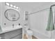 Bathroom featuring a round mirror, vanity, toilet, and shower with a patterned shower curtain at 2801 N 10Th St, Phoenix, AZ 85006