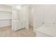 Modern bathroom with dual sinks, white cabinets, a walk-in closet, and tile floors at 37114 W La Paz St, Maricopa, AZ 85138