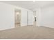 Bright bedroom with neutral carpet and white walls with doorways to a bathroom and hallway at 37114 W La Paz St, Maricopa, AZ 85138