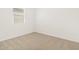 A carpeted bedroom shows a window with blinds, neutral decor, and base molding at 37114 W La Paz St, Maricopa, AZ 85138