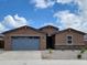 Charming single-story home with a gray garage door and desert landscaping at 37114 W La Paz St, Maricopa, AZ 85138