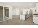 A kitchen island with granite countertops, pendant lights, and stainless steel appliances leads into a living area at 37114 W La Paz St, Maricopa, AZ 85138