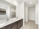 Bathroom featuring a double sink vanity, tiled floor, and walk-in closet at 37371 W San Sisto Ave, Maricopa, AZ 85138