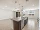 Open concept kitchen features a large island, granite countertops, stainless steel appliances, and tile flooring at 37371 W San Sisto Ave, Maricopa, AZ 85138
