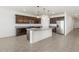 Open kitchen boasts granite countertops, stainless appliances, dark wood cabinetry, and a spacious island at 37371 W San Sisto Ave, Maricopa, AZ 85138