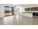 Bright living room flowing into a modern kitchen with dark cabinetry and a kitchen island at 37371 W San Sisto Ave, Maricopa, AZ 85138