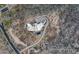 Aerial view of desert home, circular driveway, desert landscaping, and a dark bottom pool at 39602 N Charles Blair Macdonald Rd, Scottsdale, AZ 85262