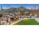 Landscaped backyard with custom waterfall feature, desert plants, gravel accents, and a mountain view at 39602 N Charles Blair Macdonald Rd, Scottsdale, AZ 85262