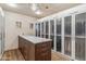 Large walk-in closet with wood floors, glass door cabinetry, a central island, and bright lighting at 39602 N Charles Blair Macdonald Rd, Scottsdale, AZ 85262