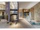Grand foyer with stone accent wall, modern lighting, and desert landscaping at 39602 N Charles Blair Macdonald Rd, Scottsdale, AZ 85262