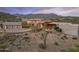 Expansive desert home showcasing modern design, three-car garage, and natural landscaping with mountain views at 39602 N Charles Blair Macdonald Rd, Scottsdale, AZ 85262