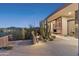 Desert modern home featuring cacti landscaping, sleek architecture, and an outdoor fireplace on a patio at 39602 N Charles Blair Macdonald Rd, Scottsdale, AZ 85262