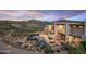 Outdoor patio with BBQ area, a pool, with desert landscaping and mountain views at 39602 N Charles Blair Macdonald Rd, Scottsdale, AZ 85262