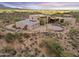 Desert home with a large three-car garage, solar panels, and circular driveway and desert landscaping at 39602 N Charles Blair Macdonald Rd, Scottsdale, AZ 85262