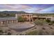 Expansive home boasts a large driveway, desert landscaping, and modern architectural details at 39602 N Charles Blair Macdonald Rd, Scottsdale, AZ 85262