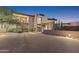 Elegant home featuring desert landscaping, a stone accent wall, and a grand entrance with ample lighting at 39602 N Charles Blair Macdonald Rd, Scottsdale, AZ 85262