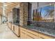 Kitchen featuring granite countertops and cabinetry with a view of the outdoor scenery at 39602 N Charles Blair Macdonald Rd, Scottsdale, AZ 85262
