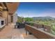 Desert landscaping surrounds the modern outdoor patio with lounge furniture, a fireplace and scenic views at 39602 N Charles Blair Macdonald Rd, Scottsdale, AZ 85262