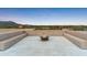 Relaxing rooftop deck boasting built-in seating and a fire pit with stunning desert views at dusk at 39602 N Charles Blair Macdonald Rd, Scottsdale, AZ 85262