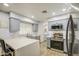 Kitchen featuring stainless steel appliances, light gray cabinetry, quartz counters, and modern finishes at 4162 W Sierra St, Phoenix, AZ 85029