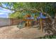 Well-maintained playset featuring slides and swings, set against a backdrop of lush greenery and a brick wall at 4162 W Sierra St, Phoenix, AZ 85029