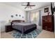 Cozy bedroom with blue accent rug, window coverings, and ceiling fan at 43228 W Knauss Dr, Maricopa, AZ 85138