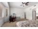 Spacious carpeted bedroom with ceiling fan, adjacent office, and ensuite bath at 43228 W Knauss Dr, Maricopa, AZ 85138