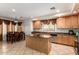 Eat in kitchen showcases an island, granite counters, stainless steel appliances, tile floors, and adjacent dining area at 43228 W Knauss Dr, Maricopa, AZ 85138