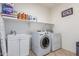 A functional laundry room with sink, counter space, washing machine and dryer at 43228 W Knauss Dr, Maricopa, AZ 85138