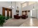 Elegant living room featuring high ceilings, a cozy fireplace, and comfortable leather seating at 43228 W Knauss Dr, Maricopa, AZ 85138