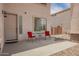 Inviting front patio features outdoor seating, perfect for enjoying warm weather and neighborhood views at 43228 W Knauss Dr, Maricopa, AZ 85138