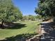 Community green space featuring a paved path with grass, mature trees, and attractive landscaping at 5029 S Carlyle Dr, Gilbert, AZ 85298