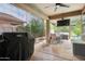 Inviting outdoor living area with shaded patio, bbq grill, tv, hot tub, and dining furniture at 5029 S Carlyle Dr, Gilbert, AZ 85298